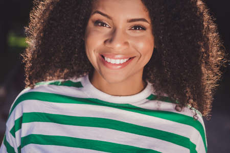 Cropped photo of young adorable african woman toothy smile whitening enjoy weekend wear modern clothes outdoorsの写真素材