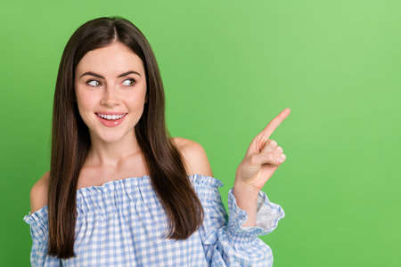 Portrait of pretty girl looking empty space promote sale discount advertisement isolated on green...
