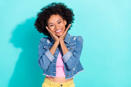 Photo of adorable shiny young lady dressed denim jacket arms cheeks smiling isolated teal color...