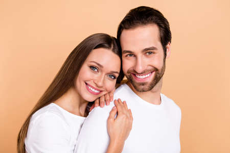 Photo of lovely millennial brown hairdo couple hug wear white cloth isolated on beige color backgroundの写真素材