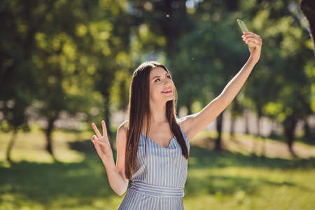 Photo of adorable brown hair girl take selfie portrait on telephone show v-sign enjoying summer...