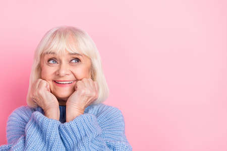 Photo of mature woman dream curious look empty space thoughtful imagination isolated over pink color...
