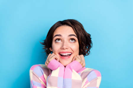 Photo of young pretty excited girl curious look empty space imagination isolated over blue color backgroundの写真素材