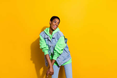 Portrait of positive friendly girl have good mood look interested empty space isolated on yellow...