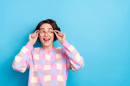 Photo of young curious lovely woman eyewear look empty space dreamy isolated over blue color...