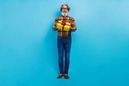 Photo of impressed man pensioner dressed checkered shirt glasses getting gift box isolated blue...