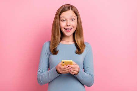 Portrait of attractive cheerful amazed girl using gadget like post smm notification isolated over...