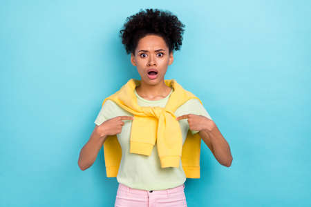 Photo of young african woman impressed indicate fingers herself puzzled isolated over blue color backgroundの写真素材