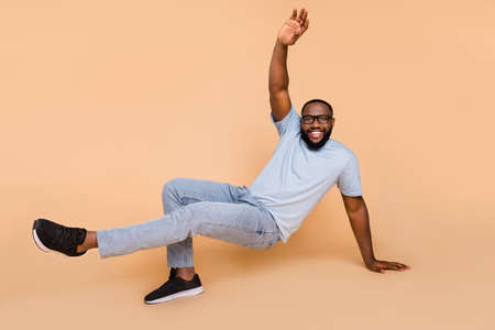 Full length body size view of attractive cheerful guy moving dancing break style isolated over beige...