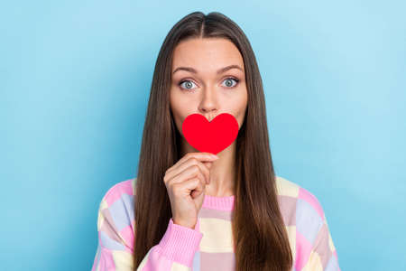 Photo of nice speechless lady in love hold small heart card cover mouth wear casual clothes isolated blue color backgroundの写真素材