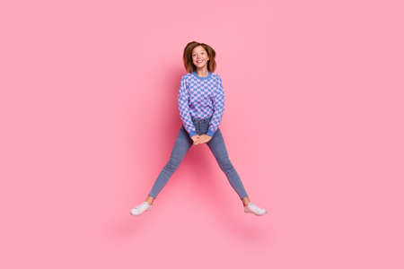 Full size photo of blond little girl jump wear sweater jeans sneakers isolated on pink background