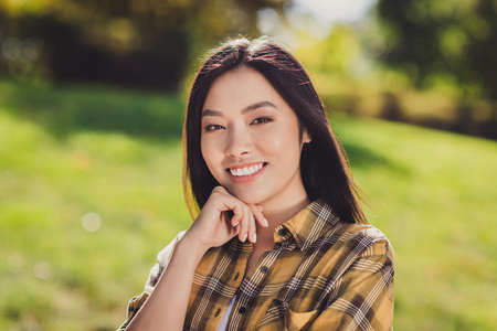 Photo of charming shiny young woman dressed plaid shirt walking smiling arm cheek cheekbone outside nature countryside landscapeの写真素材