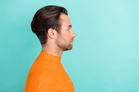 Profile photo of calm young man look empty space wear pullover isolated on turquoise color...