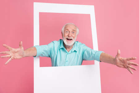 Photo of rejoice middle aged man open hands cuddle photograph border isolated pastel color...