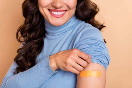 Photo of confident positive woman wear blue sweater showing shoulder sticky plaster isolated beige...