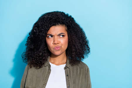 Photo of young moody african lady look empty space minded thoughtful isolated over blue color...