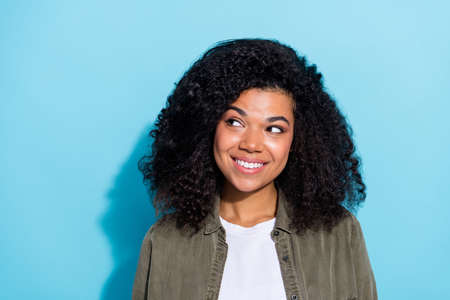 Photo of young cheerful lovely african girl dreamy curious look empty space isolated over blue color...