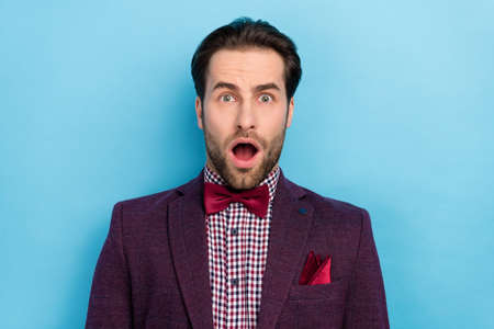 Portrait of stunned amazed negative mood male with open mouth screaming in despair isolated on blue color backgroundの写真素材