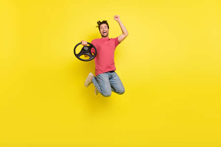 Full length photo of cool beard millennial guy drive hooray jump wear red t-shirt jeans shoes...