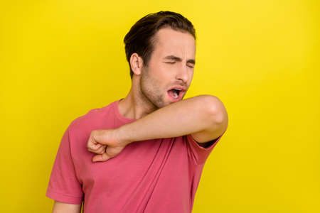 Photo of tired exhausted student feel asleep yawn shoulder cover mouth wear pink t-shirt isolated yellow color backgroundの写真素材