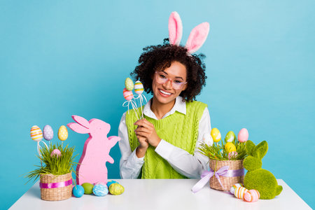 Photo of charming good mood lady celebrate easter holiday prepare for eggs hunt isolated on blue color backgroundの写真素材