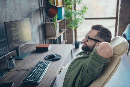 Profile side view portrait of attractive skilled dreamy brunet guy developing web site project start-up at work workplace workstation indoorsの写真素材