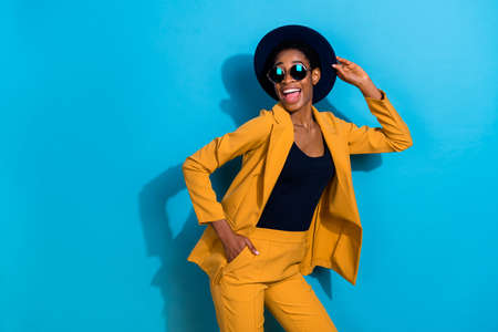 Photo of positive funky person have fun good mood hand touch hat isolated on blue color backgroundの写真素材