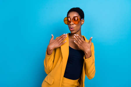 Portrait of astonished nice person plump lips raise hands unbelievable isolated on blue color backgroundの写真素材