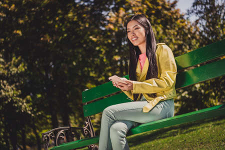 Portrait of attractive cheerful long-haired girl listening stereo rock sound spending time pastime weekend outdoorsの写真素材