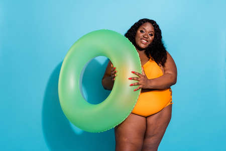 Photo of curvy chubby oversize lady tourist hold buoy want swim ocean isolated over blue color backgroundの写真素材