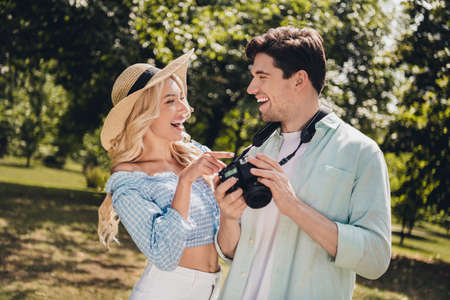 Portrait of two attractive cheerful glad couple choosing captures of model portfolio laughing having fun outdoorsの写真素材