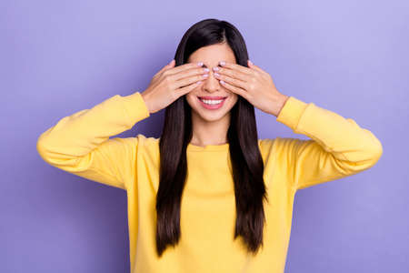 Photo of good mood adorable cute lady covering eyes playing fooling around isolated on purple color backgroundの写真素材
