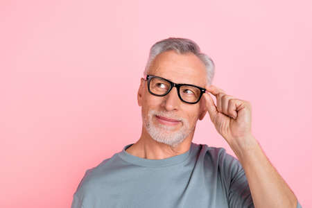 Photo of confident dreamy man pensioner dressed grey shirt arm glasses looking empty space isolated...