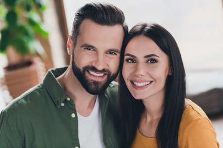 Portrait of attractive adorable cheerful couple cuddling hugging staying safe self isolation at home house flat indoorsの写真素材