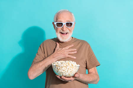 Portrait of attractive funky impressed cheerful grey-haired man watching film rest isolated over...