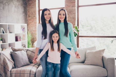 Photo of three attractive ladies good mood hug enjoy free-time standing living-room flat wear casual...