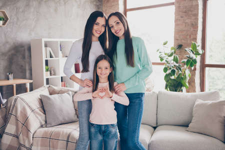 Photo of bonding family little girl demonstrate heart shape symbol valentine day concept wear casual clothes home indoorsの写真素材