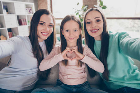 Photo of cheerful mommy with siblings shoot picture sit sofa relationship heart shape cozy relax rest weekend flat indoorsの写真素材