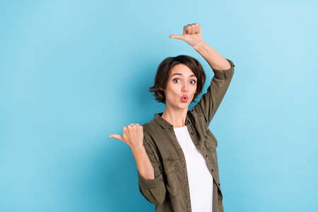 Photo of impressed young bob hairdo lady index promo wear khaki shirt isolated on blue color...