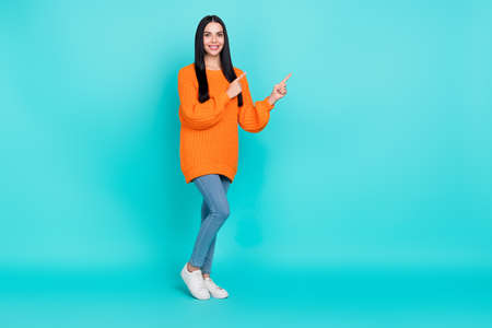 Photo of funny shiny lady dressed knitted pullover pointing fingers empty space isolated teal color...
