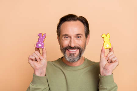 Portrait of attractive cheerful funny man holding in hand sweet bunny easter time isolated over...