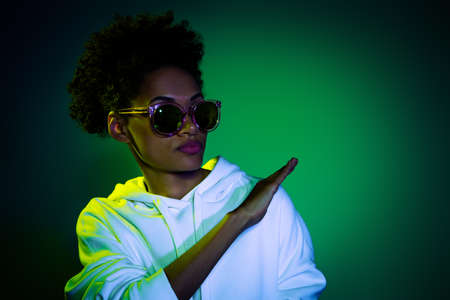 Photo of cool charming woman wear sweatshirt dark eyeglasses dancing empty space isolated green color backgroundの写真素材