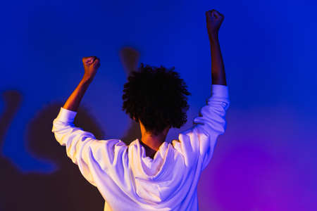 Photo of adorable pretty lady dressed hoodie dark eyewear dancing rising fists isolated purple color backgroundの写真素材