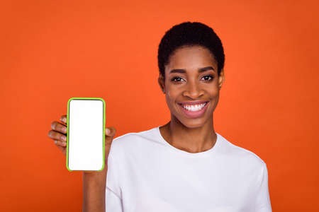 Photo of stylish trendy adrogyne lady hold digital device promo choose isolated shine color backgroundの写真素材