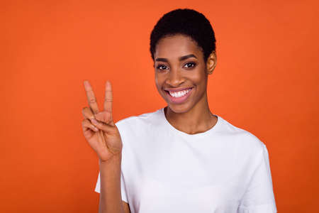 Portrait of transgender woman make v-sign identity wear white stylish trendy t-shirt isolated bright...