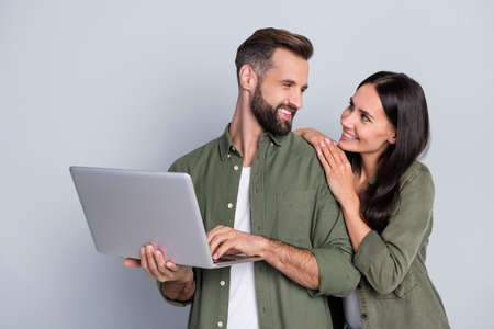 Photo of affectionate married guy lady use netbook browsing web discount typing isolated over grey...