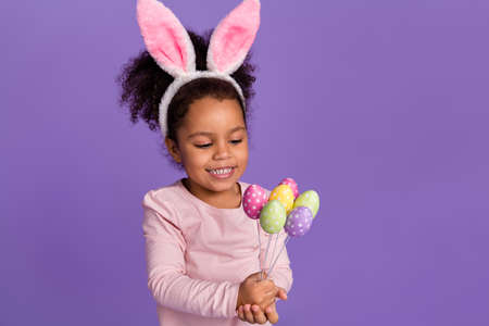 Portrait of attractive little small trendy pre-teen girl holding handicraft eggs isolated over...