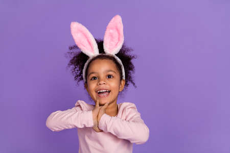 Portrait of attractive cheery cute amazed pre-teen girl wear bunny ears having fun isolated over bright purple violet color backgroundの写真素材