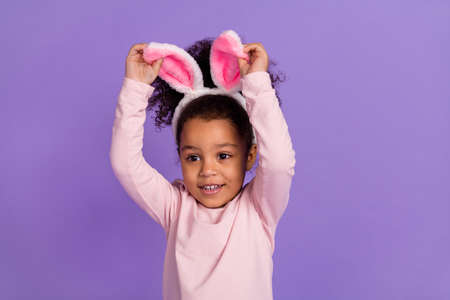 Portrait of attractive cheery cute sweet pre-teen girl wearing bunny ears accessory isolated over...