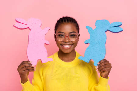 Photo of funky positive girl hold two rabbit decoration figure isolated on pink color background